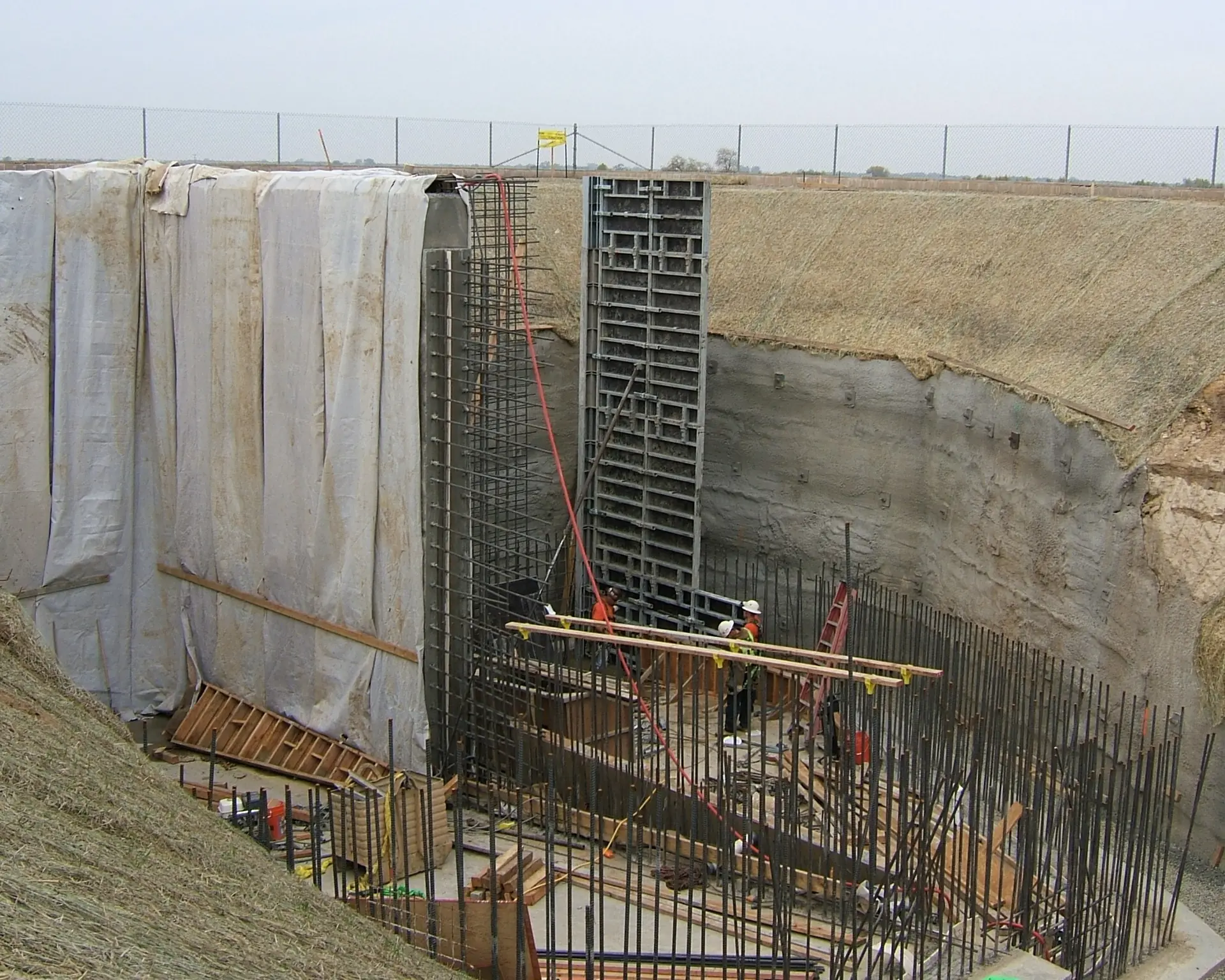 Cast-in-place concrete walls against a shored excavation face.