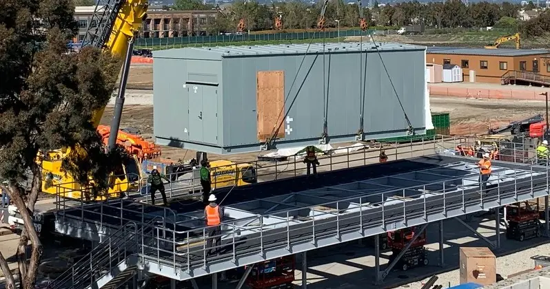 Switchgear and battery building on a pile-supported elevated structural steel frame.